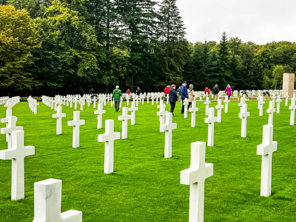 People walking among the rows of white crosses at the Luxembourg American Cemetery