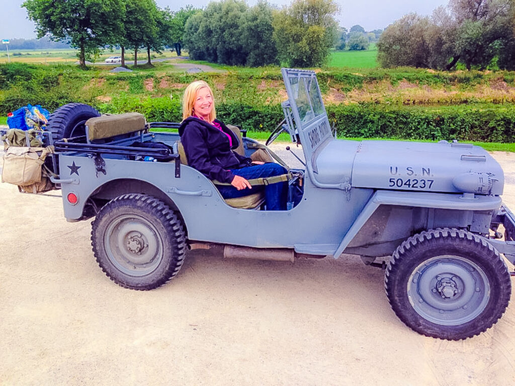 Author sits in a 1940s Jeep touring Utah Beach in Normandy, France