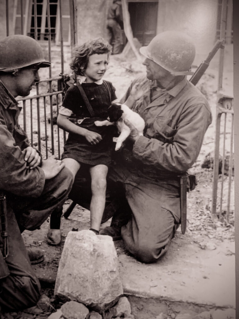 WWII photo of a soldier with a child at the Bayeux Memorial Museum of the Battle of Normandy 