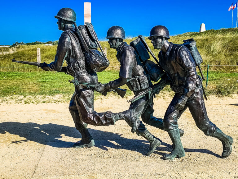 Utah beach memorial of three soldiers running onto the beach on D-Day in WWII