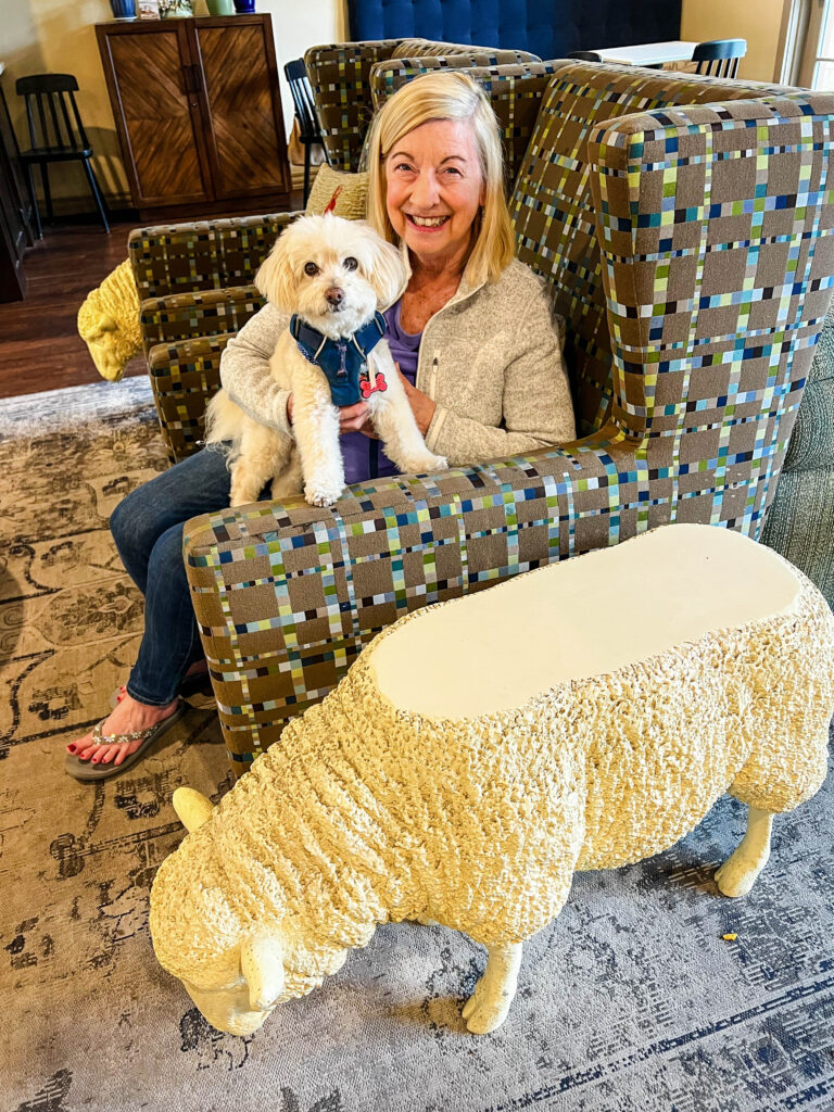 Woman with her puppy and the sheep end table in the lobby of the Agrarian Hotel in Arroyo Grande