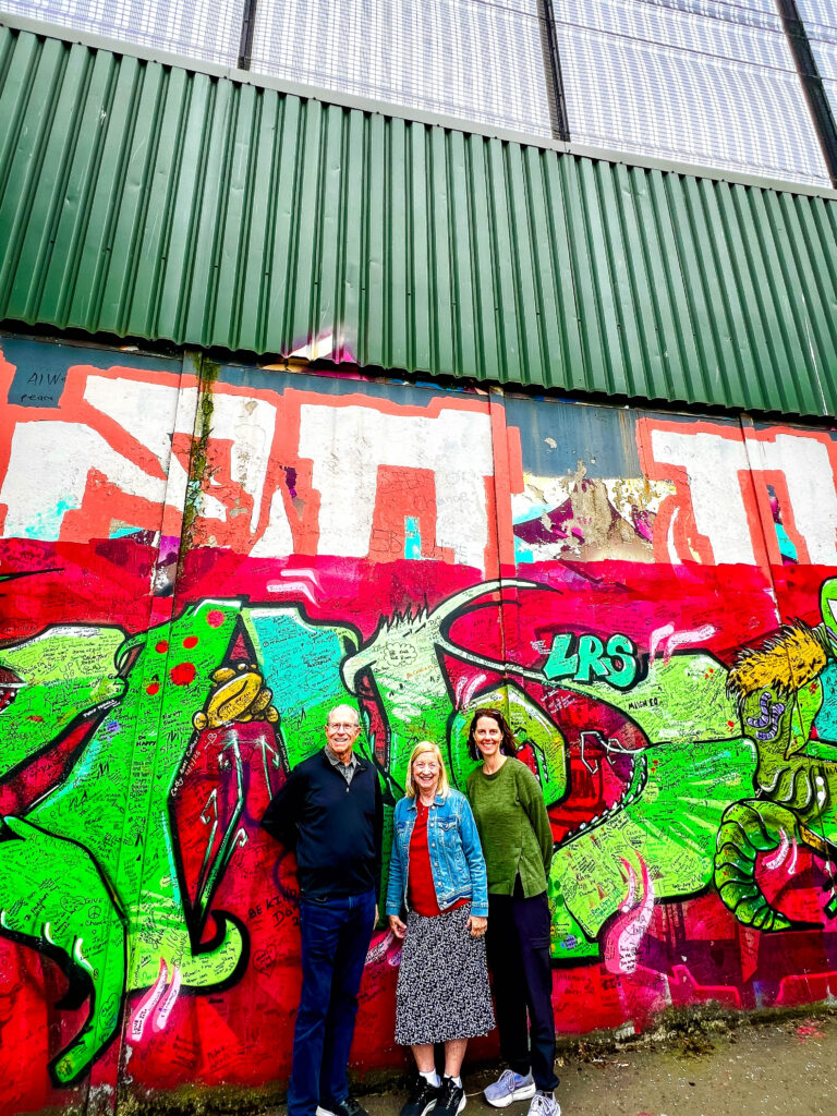 Three visitors at the Peace Wall in Belfast